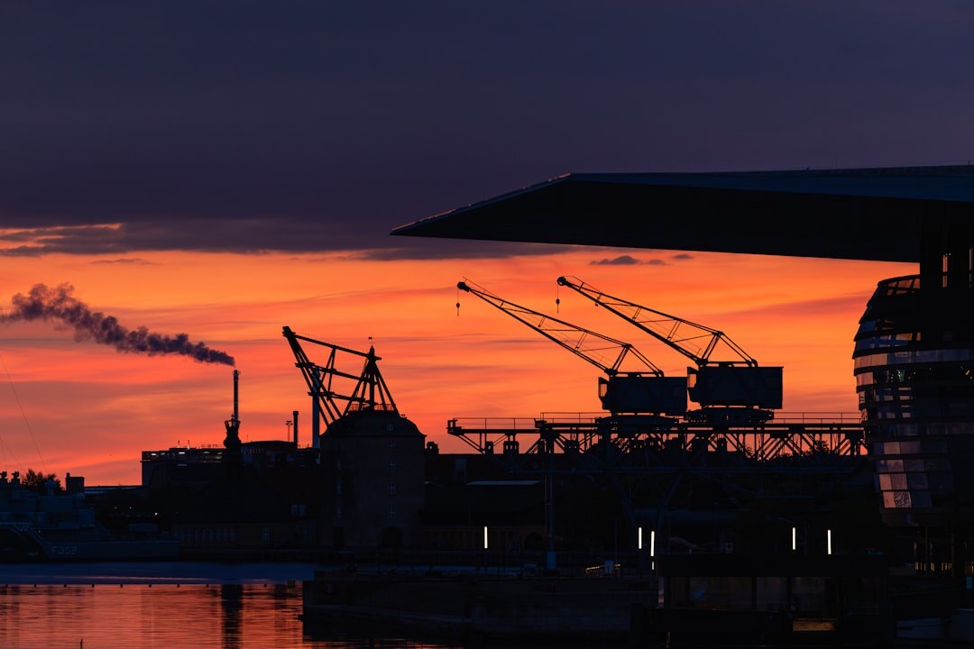 Industrial harbor cranes and containers at a Danish port at dawn
