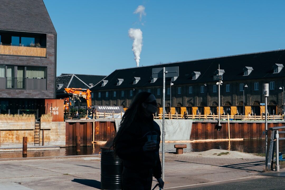 Portrait of a Danish documentary photographer holding a camera outdoors