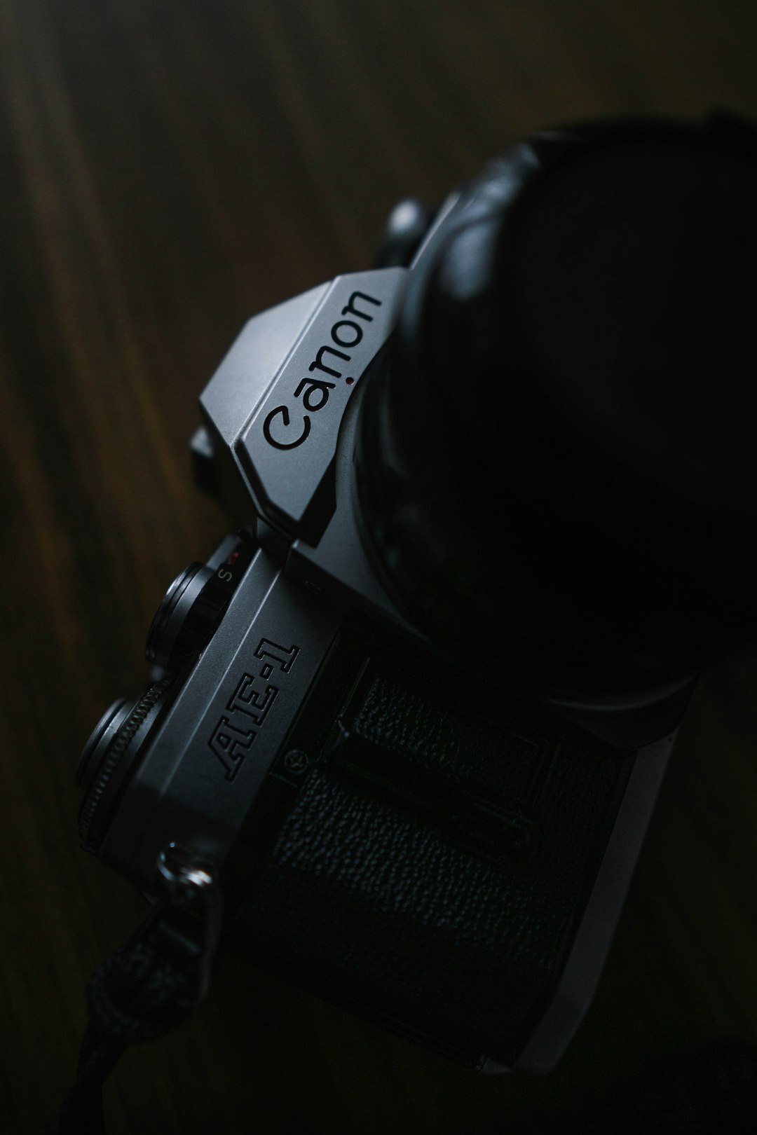 Close-up of a worn analog camera resting on a wooden table