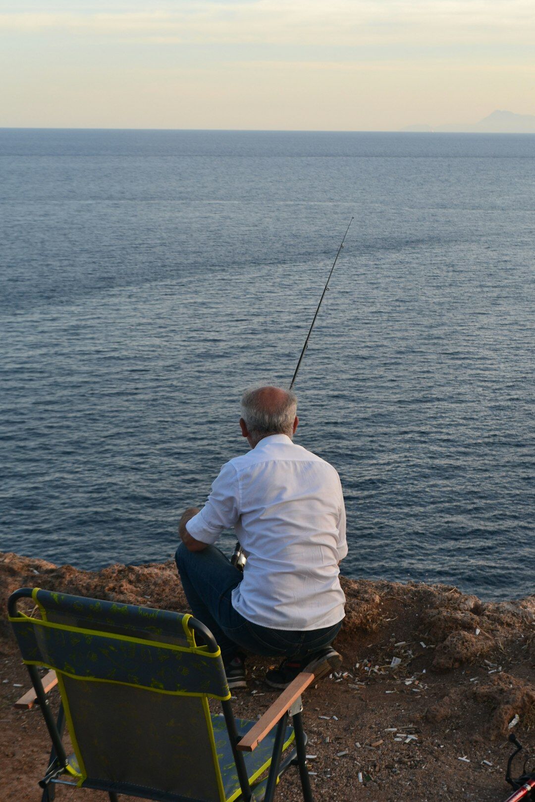 elderly fisherman by sea